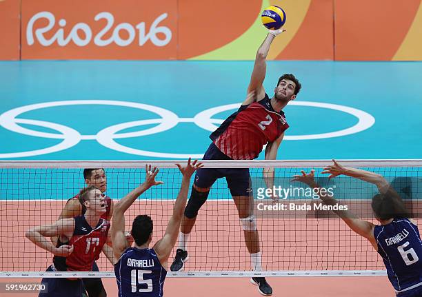 Aaron Russell of United States spikes at the Italy defence during the Men's Volleyball Semifinal match on Day 14 of the Rio 2016 Olympic Games at the...