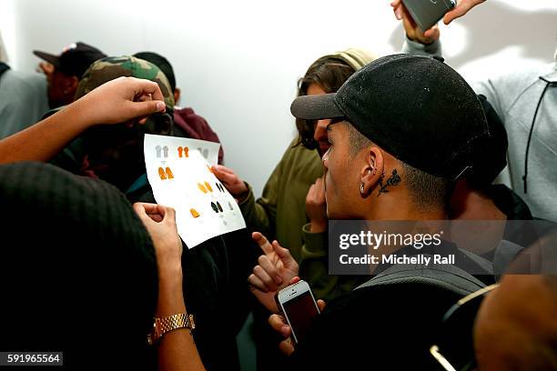 Shoppers queue to buy the latest apparel from Kanye West at the Kanye West temporary PABLO Store in 107 Bree Street on August 19, 2016 in Cape Town,...