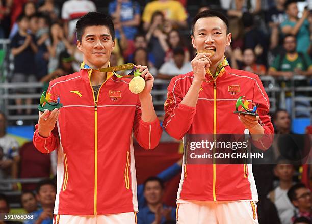 Gold medalists China's Zhang Nan and China's Fu Haifeng stand with their medals on the podium following the men's doubles Gold Medal badminton match...