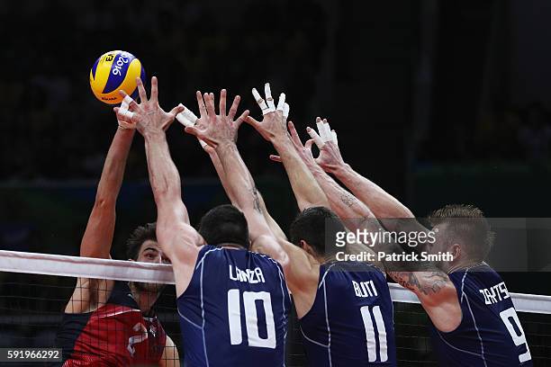 Aaron Russell of United States spikes against the Italy defence during the Men's Volleyball Semifinal match on Day 14 of the Rio 2016 Olympic Games...