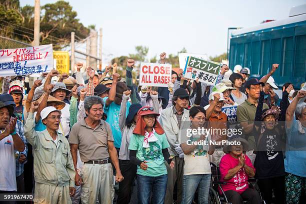 Anti U.S base protesters raise their fists in the air to protest against the construction of helipads in front of the main gate of U.S. Military's...