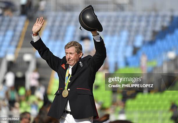 Britain's Nick Skelton celebrates with his gold medal in the individual equestrian show jumping event at the Olympic Equestrian Centre during the Rio...