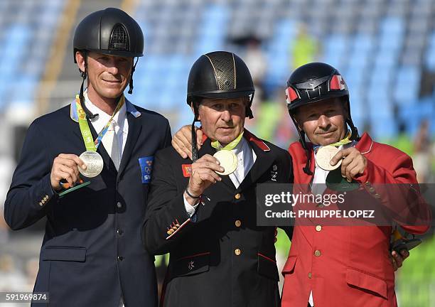 Britain's Nick Skelton poses with the gold medal, next to Sweden's Peder Fredricson with the silver and Canada's Eric Lamaze with bronze after the...