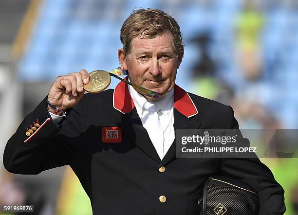 Britain's Nick Skelton poses with his gold medal in the individual equestrian show jumping event at the Olympic Equestrian Centre during the Rio 2016...