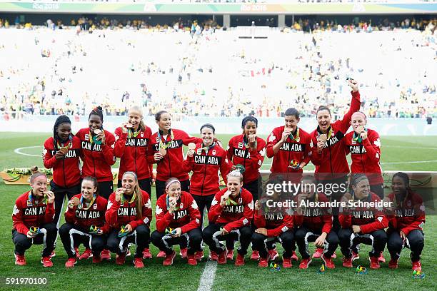 Canadian team celebrates with their medals following victory during the Women's Olympic Football Bronze Medal match between Brazil and Canada at...