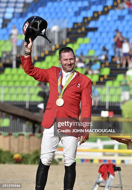 Canada's Eric Lamaze poses with his bronze gold medal after the individual equestrian show jumping event at the Olympic Equestrian Centre during the...