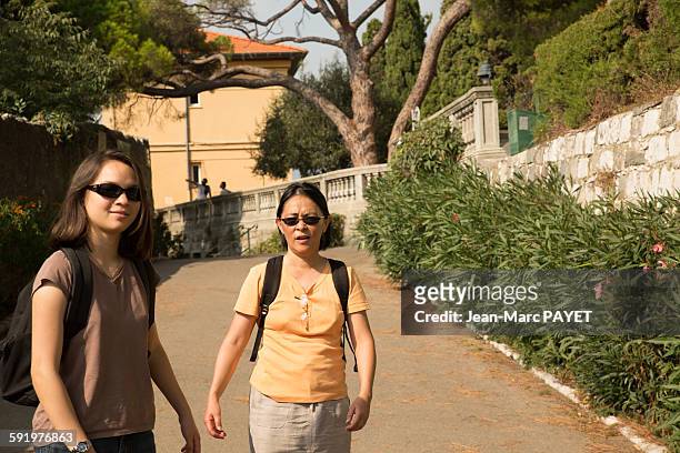 two asian women walking in the street - jean marc payet stock-fotos und bilder