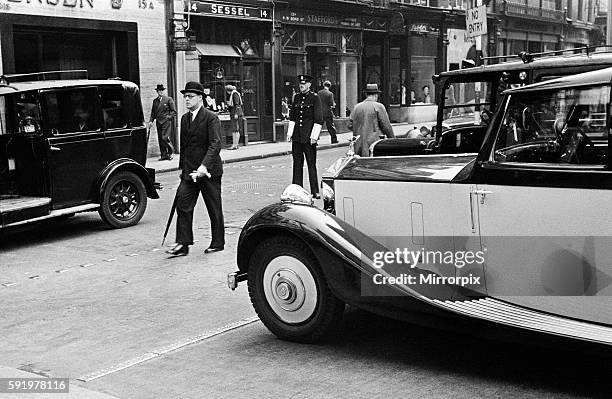 Scenes in Bond Street, Central London with man wearing bowler hat and holding an umbrella crossing the road. October 1947.
