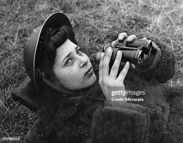 Girl mans the searchlight Sstation somewhere in South East London. Lookout is wearing a fur coat to keep herself warm through the night. March 1943...