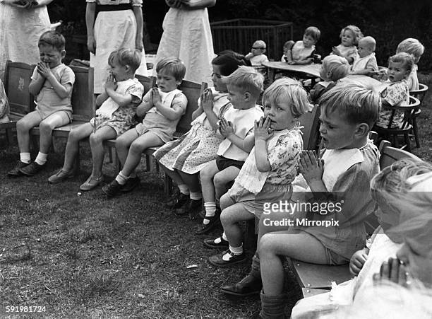 Children saying prayers before dinner time a t a nursery in England during the war. August 1941