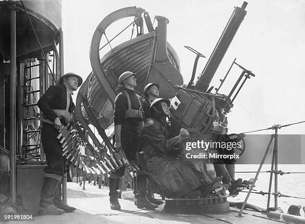 British Royal Navy sailors aboard a destroyer on escort duty fire warning shots to an unidentified aircraft by a 2 pounder pom pom gun on deck May...