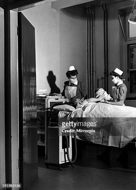 Midwives deliver a new born baby inside thew Labour ward at the British Hospital for Mothers and Babies in Woolwich, London. 20th January 1948.