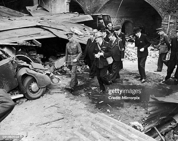 King George VI walks past a wrecked car on a walkabout in the East End of London following a Nazi air raid. 10th September 1940.