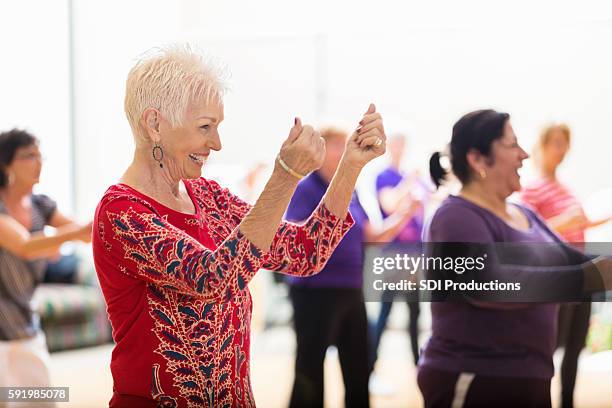 senior woman enjoys dance class - young at heart stock pictures, royalty-free photos & images