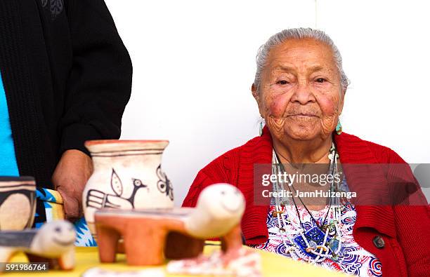 2016 santa fe indian market: kewa pueblo potter with work - puebloan culture stock pictures, royalty-free photos & images