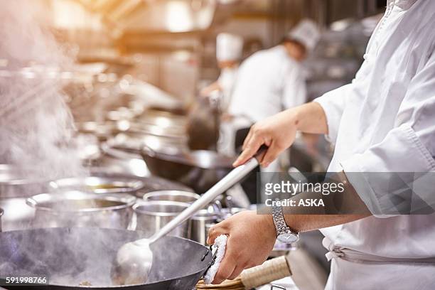chef nel ristorante di cucina in cucina con pentole - cucina domestica foto e immagini stock