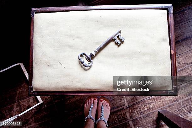 woman standing near skeleton key on table - ornate key stock pictures, royalty-free photos & images