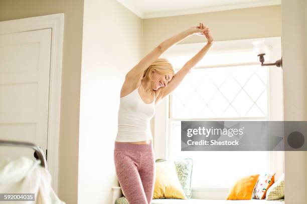 caucasian woman stretching in bedroom - woman waking up happy stock pictures, royalty-free photos & images