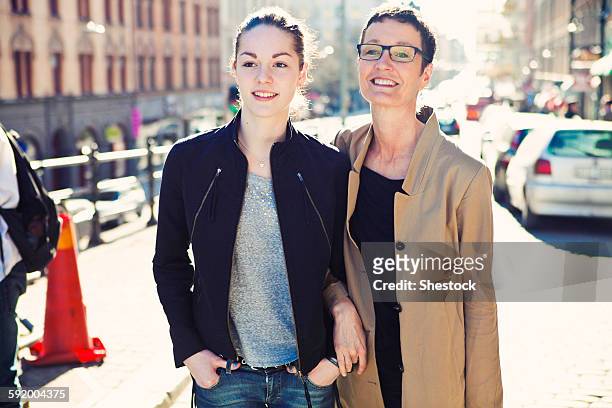 caucasian mother and daughter walking on city sidewalk - adolescent daughter mother portrait stock-fotos und bilder
