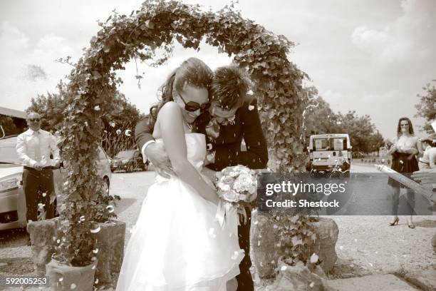 caucasian bride and groom walking through archway - wedding ceremony alter stock pictures, royalty-free photos & images