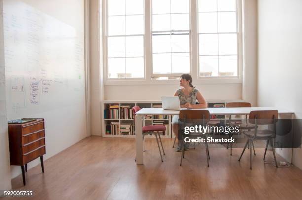 caucasian businesswoman working on laptop in office - teacher preparation stock pictures, royalty-free photos & images