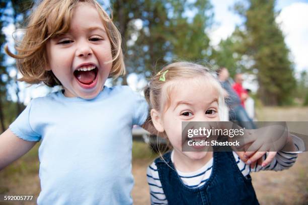 close up of caucasian sisters hugging outdoors - girl close up stock-fotos und bilder