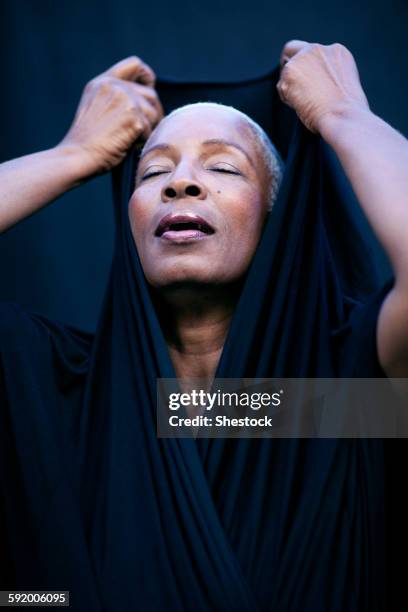 close up of woman covering her head with shawl - covering gray hair stock pictures, royalty-free photos & images