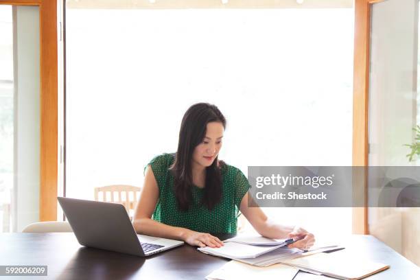 korean woman paying bills on laptop - learning resources for reading stock-fotos und bilder