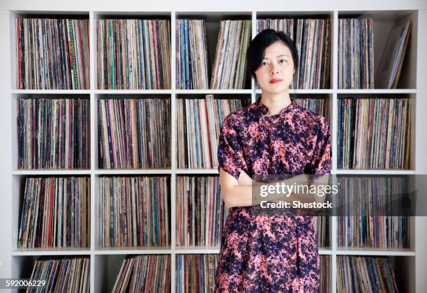 taiwanese woman standing near record collection - collections stock-fotos und bilder