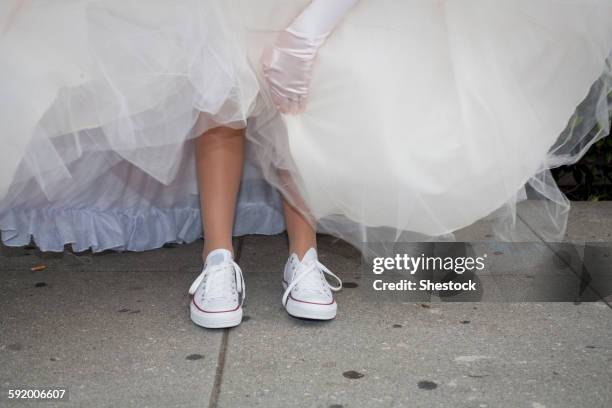 teenage girl wearing sneakers under quinceanera dress - wedding anticipation stock pictures, royalty-free photos & images