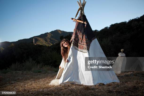 hispanic woman smiling in teepee in field - teepee stock pictures, royalty-free photos & images