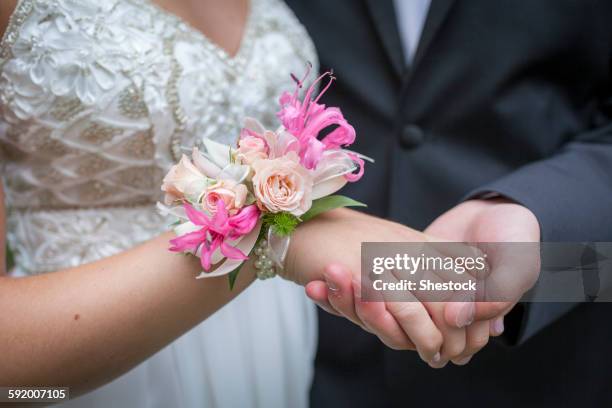 close up of teenage couple holding hands in prom attire - corsage imagens e fotografias de stock