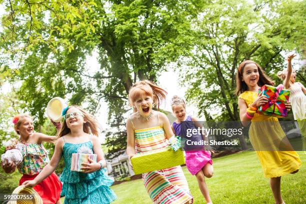 girls carrying gifts at birthday party - children birthday party foto e immagini stock