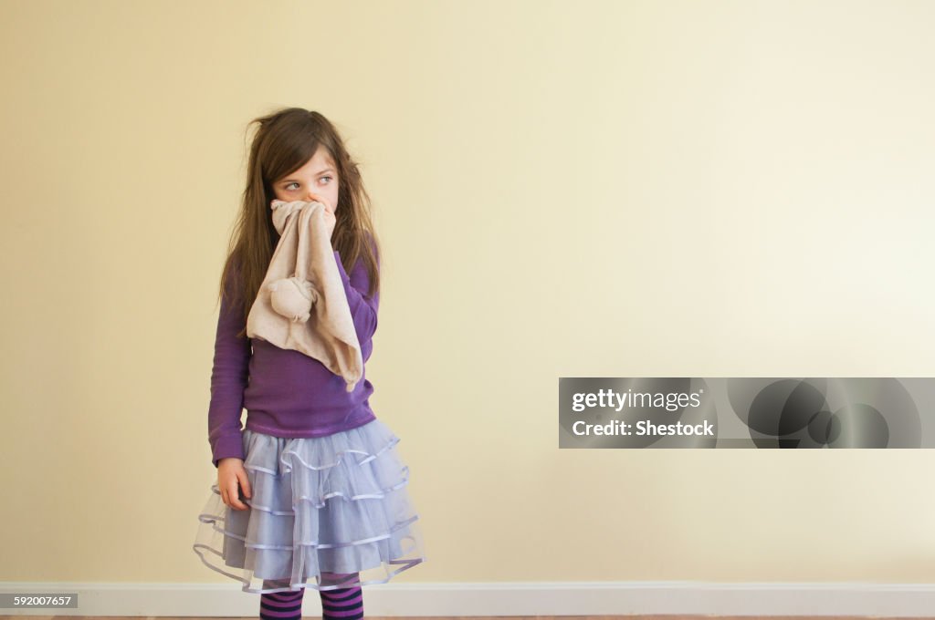 Sick Caucasian girl wiping nose