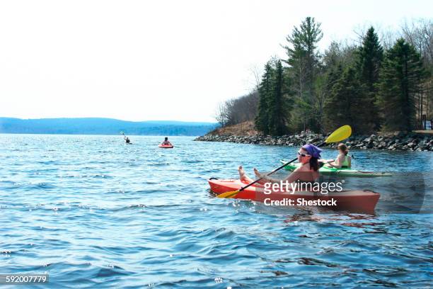 friends rowing kayaks in lake - warminster stock pictures, royalty-free photos & images
