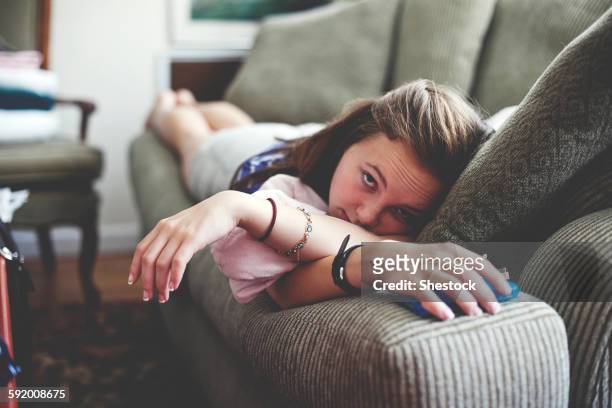 close up of girl laying on sofa in living room - girl close up stock-fotos und bilder