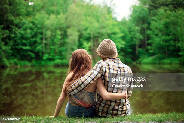 rear view of couple hugging near lake - casal adolescente imagens e fotografias de stock
