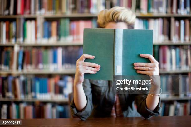 woman reading book in library - library　woman stock-fotos und bilder