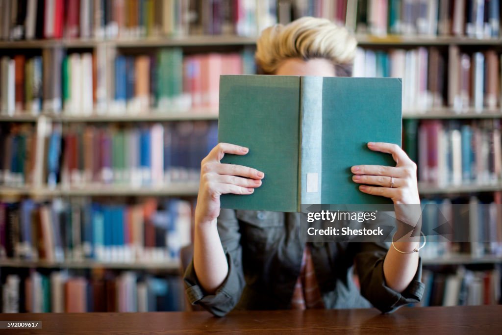 Woman reading book in library