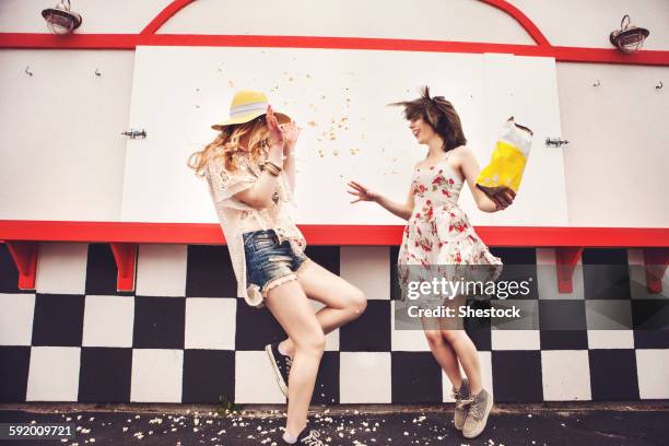 caucasian friends having popcorn fight outdoors - food fight stock pictures, royalty-free photos & images
