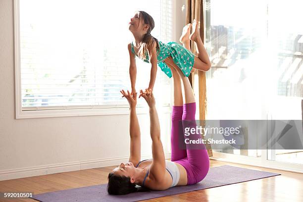 Mother and daughter practicing yoga in studio
