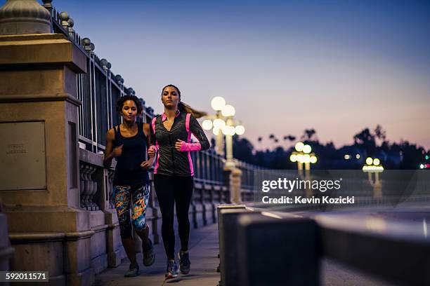 joggers running on bridge, arroyo seco park, pasadena, california, usa - maillot de sport stockfoto's en -beelden