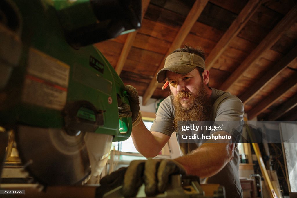 Wood artist using machinery in workshop