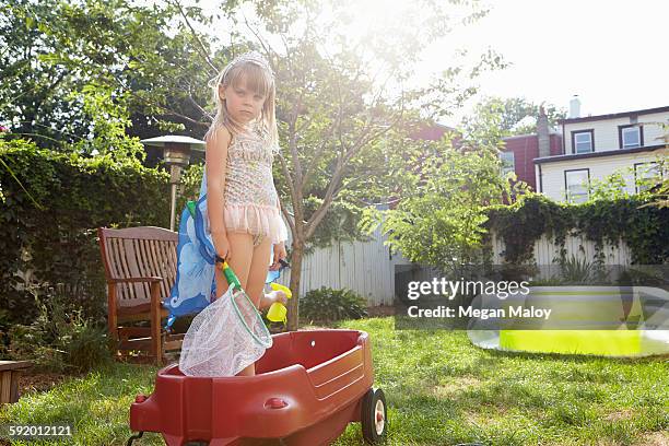 girl in butterfly costume standing in toy wagon - toy wagon stock pictures, royalty-free photos & images