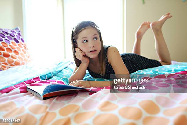 girl reading book on bed - barefoot girl stock pictures, royalty-free photos & images