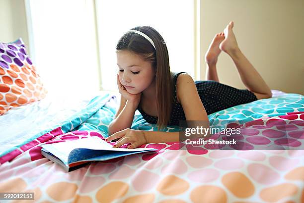 calm girl reading book on bed - barefoot girl stock pictures, royalty-free photos & images