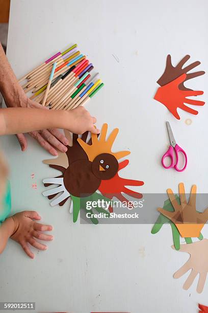 students and teacher making thanksgiving turkey crafts in classroom - turkey school stockfoto's en -beelden