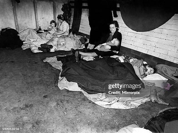 Woman feeding her baby in an underground tube station used as an air raid shelter during the war, London. November 1943
