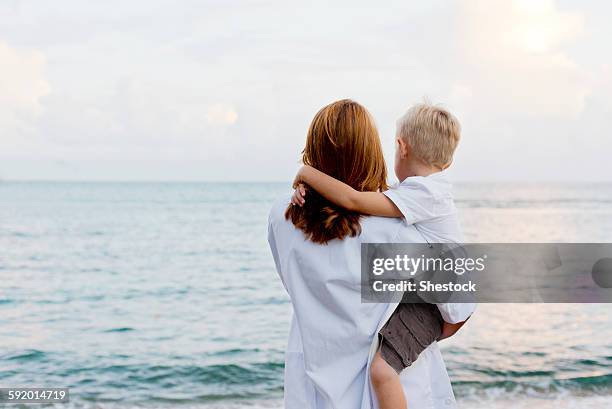 mother and son admiring ocean - woman son stock pictures, royalty-free photos & images