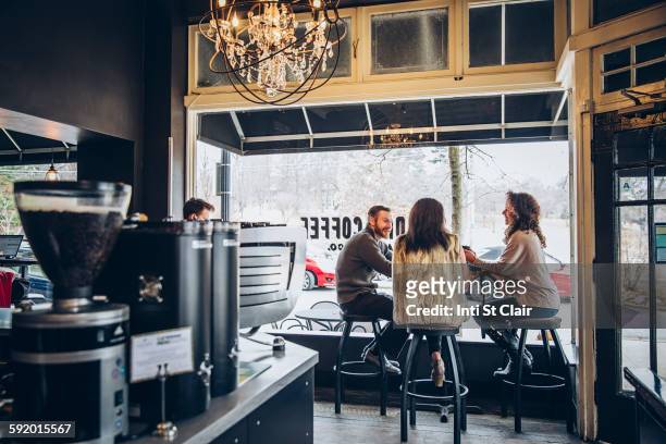 friends drinking coffee in cafe - persona in secondo piano foto e immagini stock